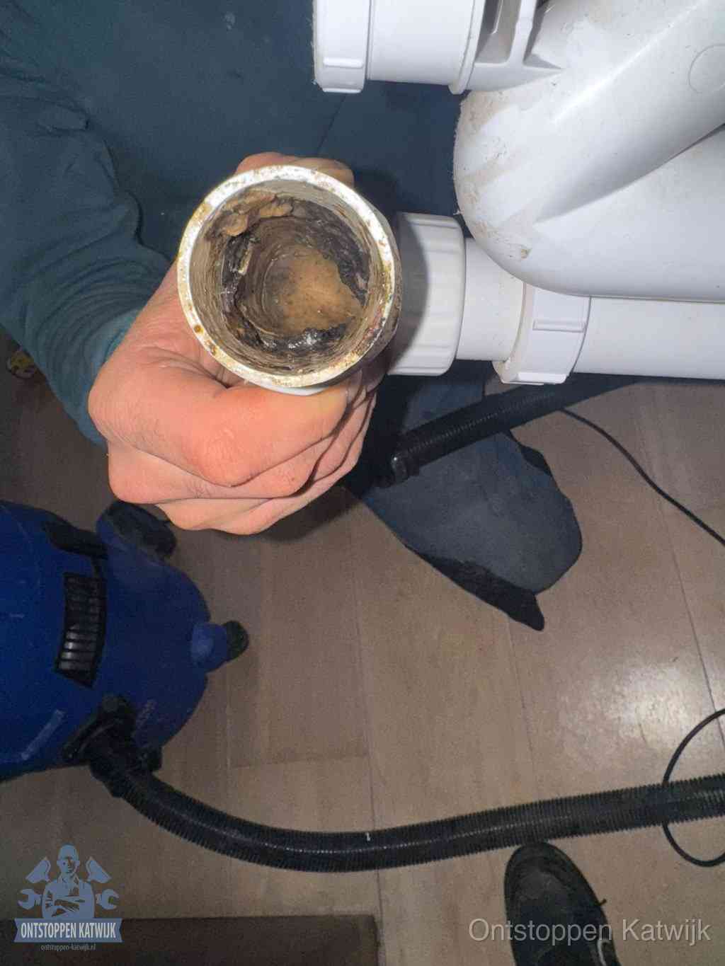 Een losgekoppeld afvoerbuisstuk dat van binnen volledig is dichtgeslibd, het gevolg van een verstopping te lang laten zitten in Katwijk