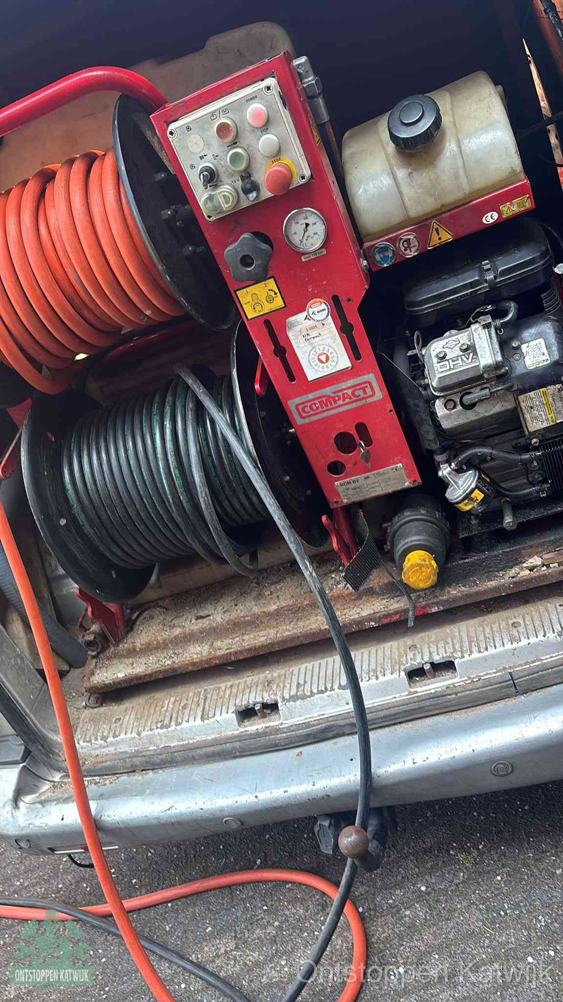 Een rood hogedruk-rioolreinigingstoestel in de laadbak van de bedrijfsbus, apparatuur voor een hardnekkige afvoerverstopping in Katwijk