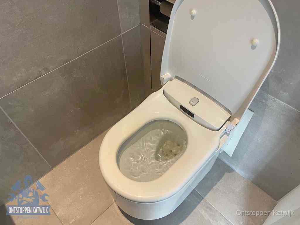 Een toiletpot vol troebel water met drijvend papier en restanten, de meest voorkomende oorzaak van een verstopte wc in Katwijk