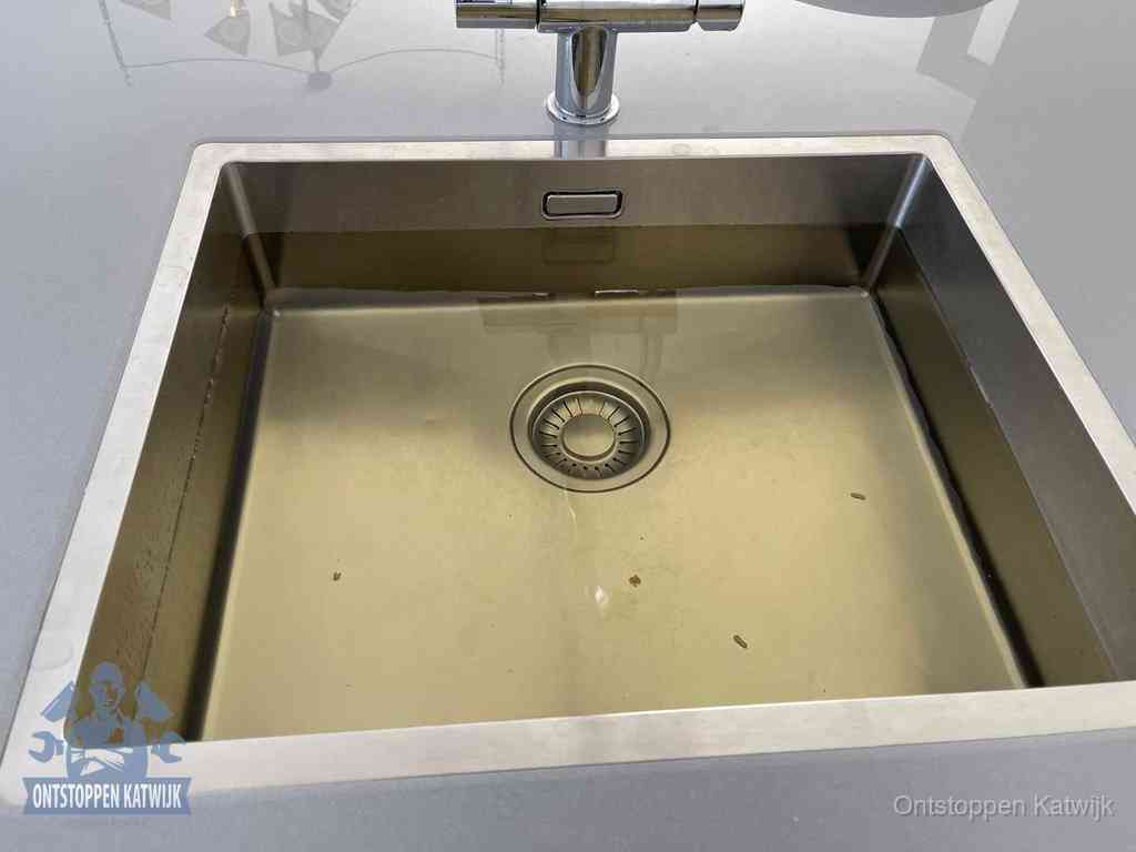Stilstaand water in een rvs spoelbak dat niet wegloopt, een duidelijk signaal van een gootsteenverstopping in Katwijk